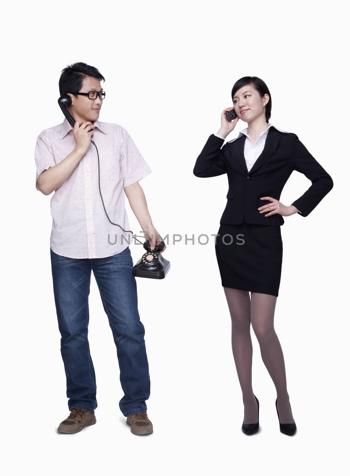 Businesswoman on the phone, man with stationary phone
