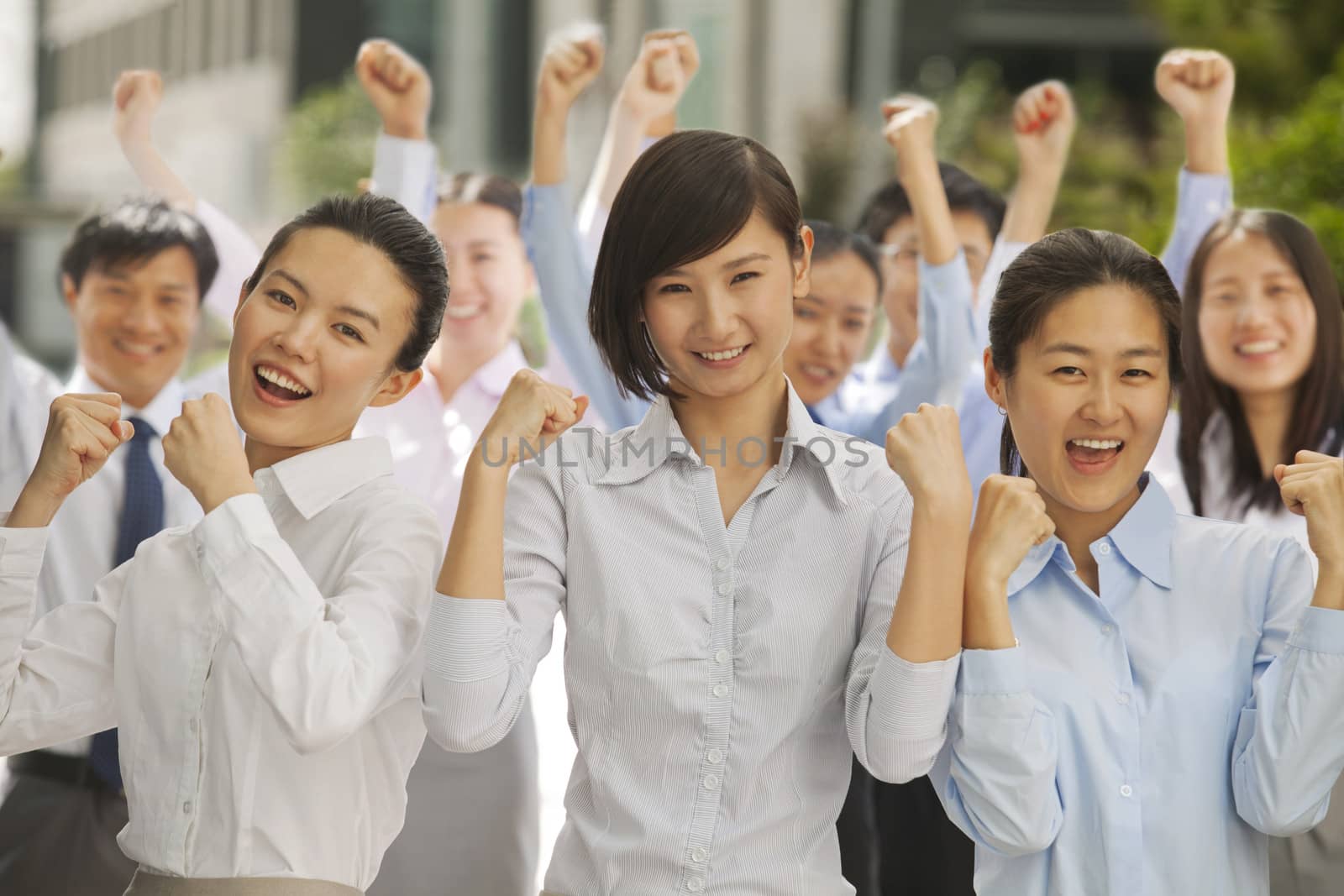 Portrait of group of business people cheering with fists up