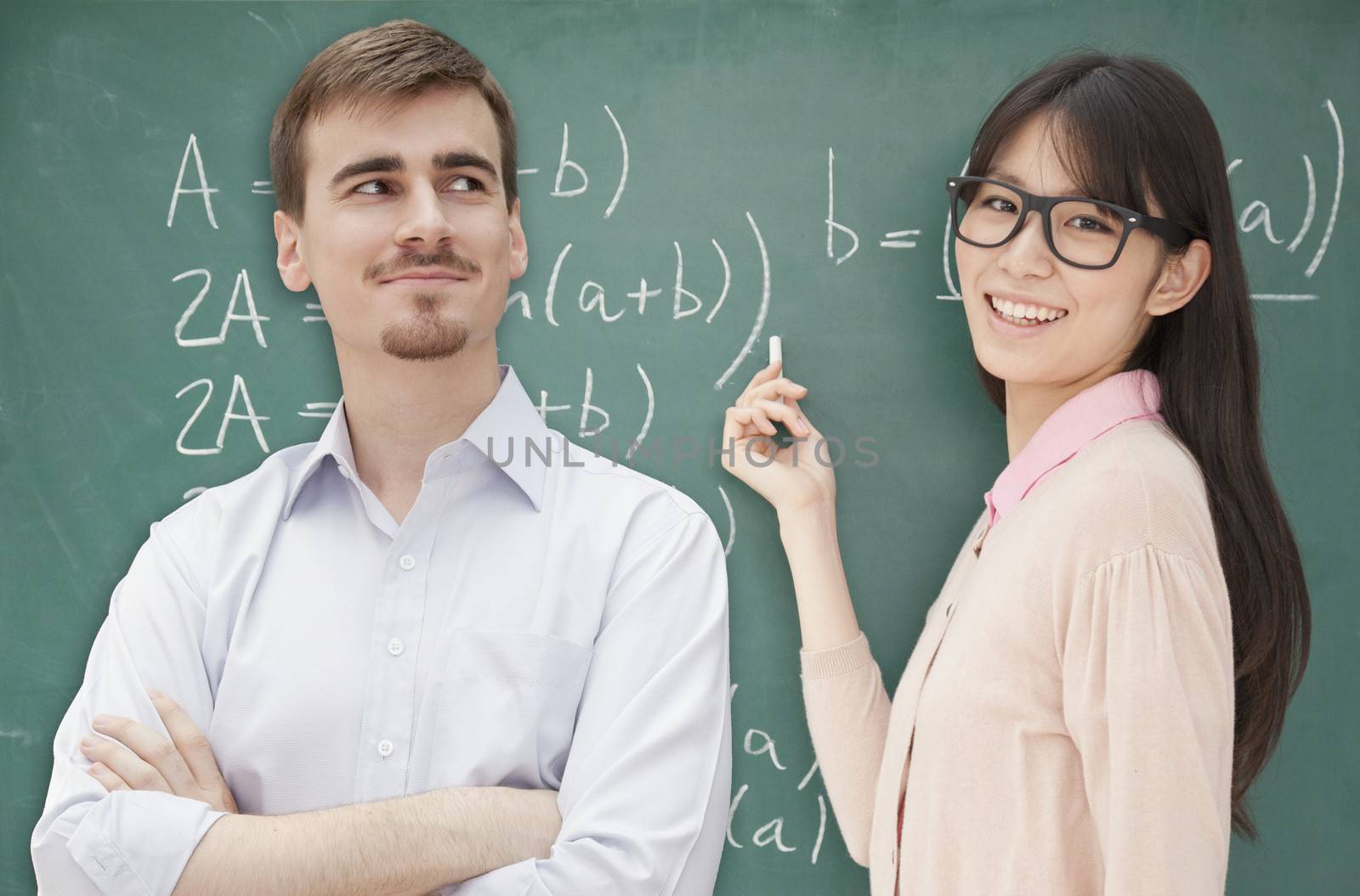 Two students doing math formula on the chalkboard, Beijing