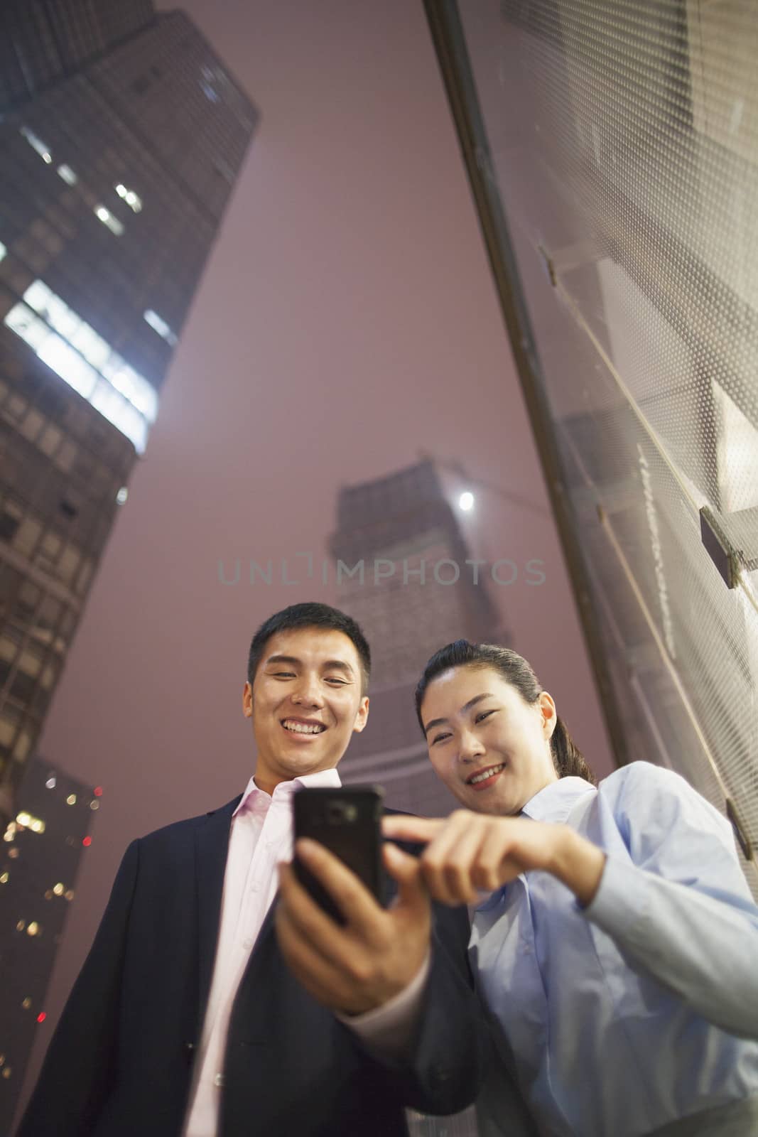 two business people smiling and looking at the phone
