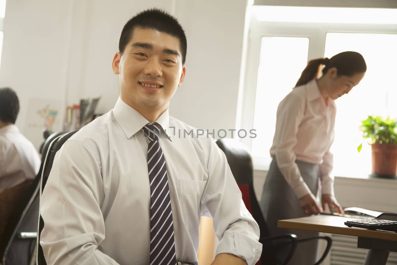 Office worker seating and smiling, portrait