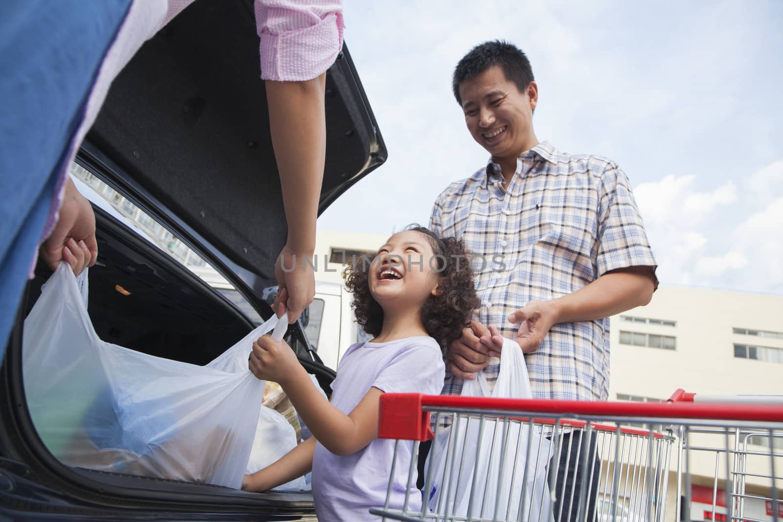 Family talking next to the car with shopping bags