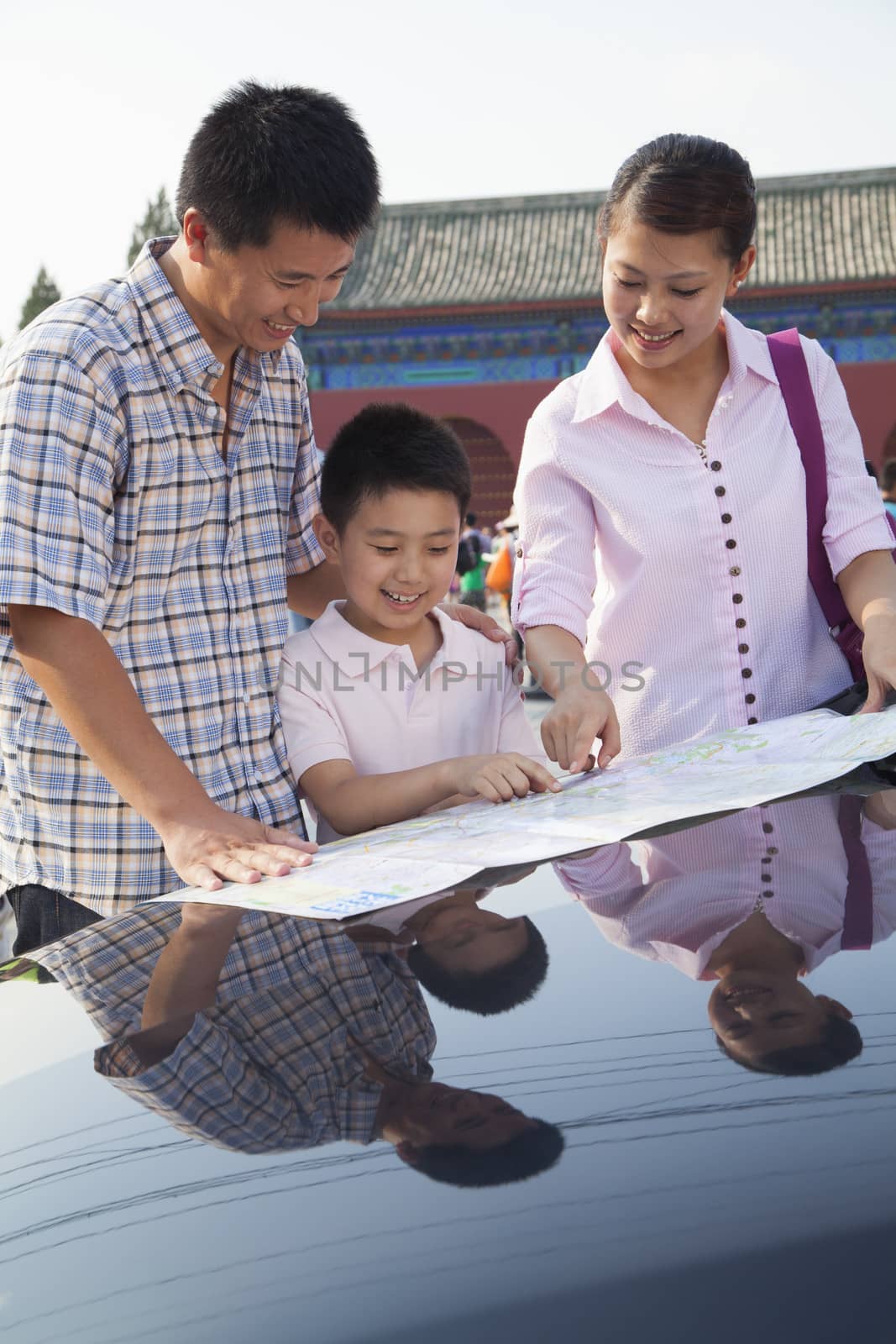 Family standing next to the car and looking at the map