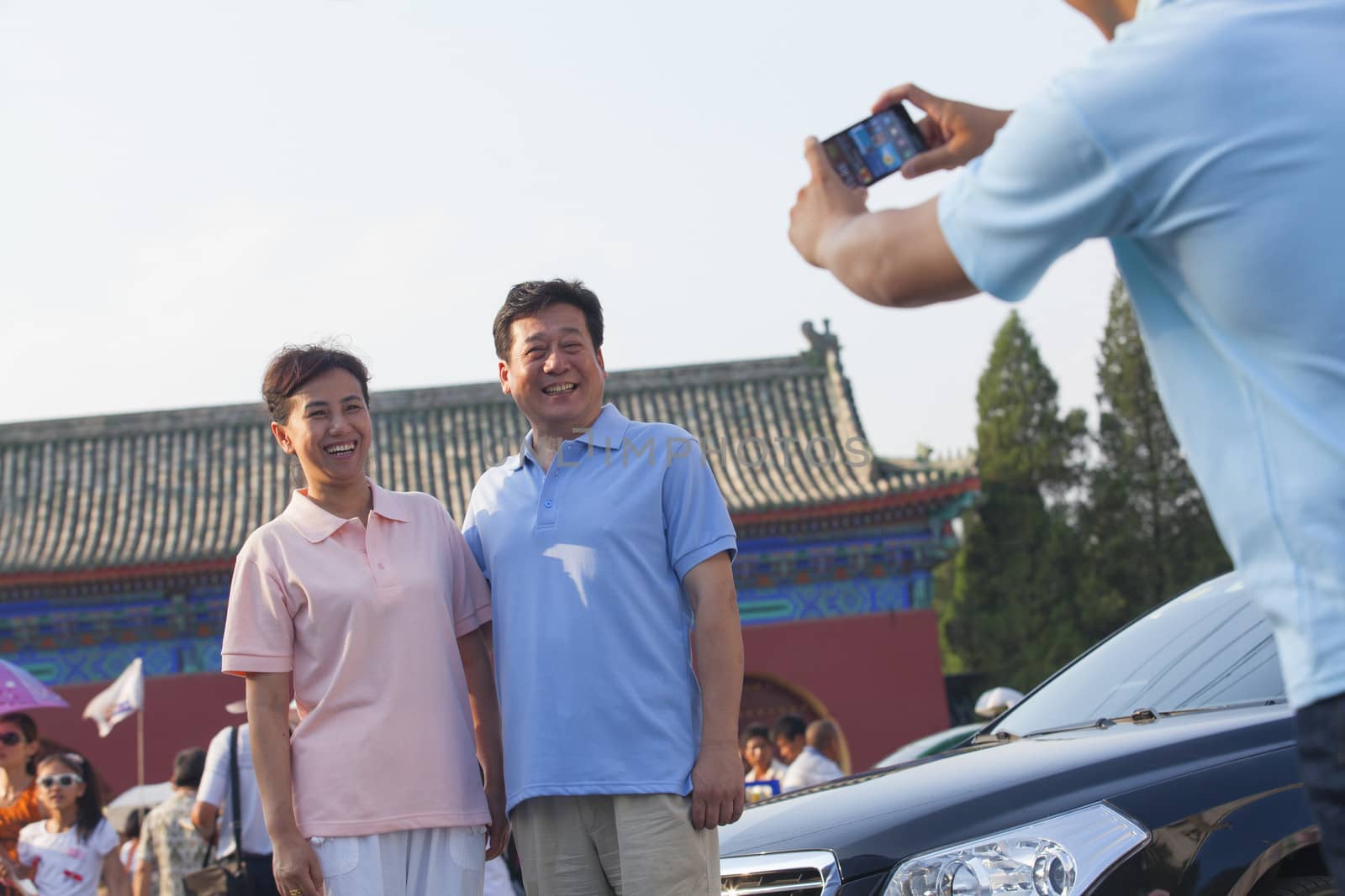 Son taking photo of his parents with his cell phone