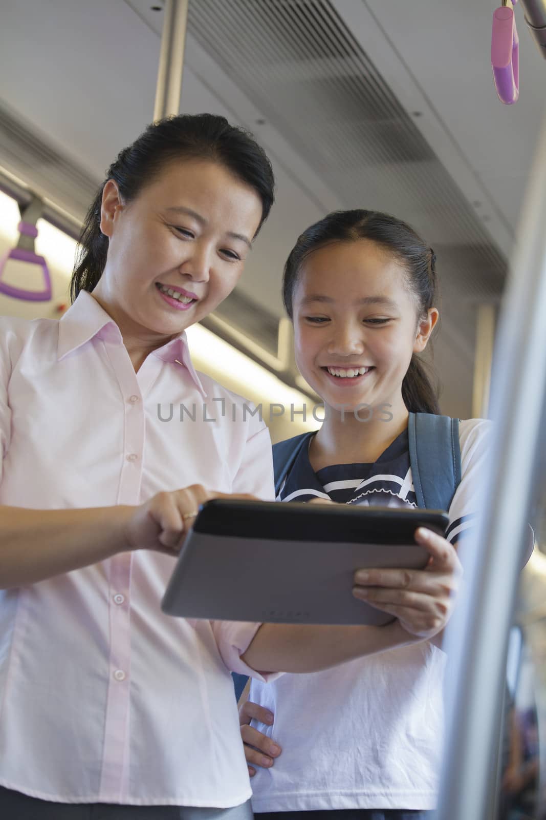 Mather and daughter watching a movie in the subway