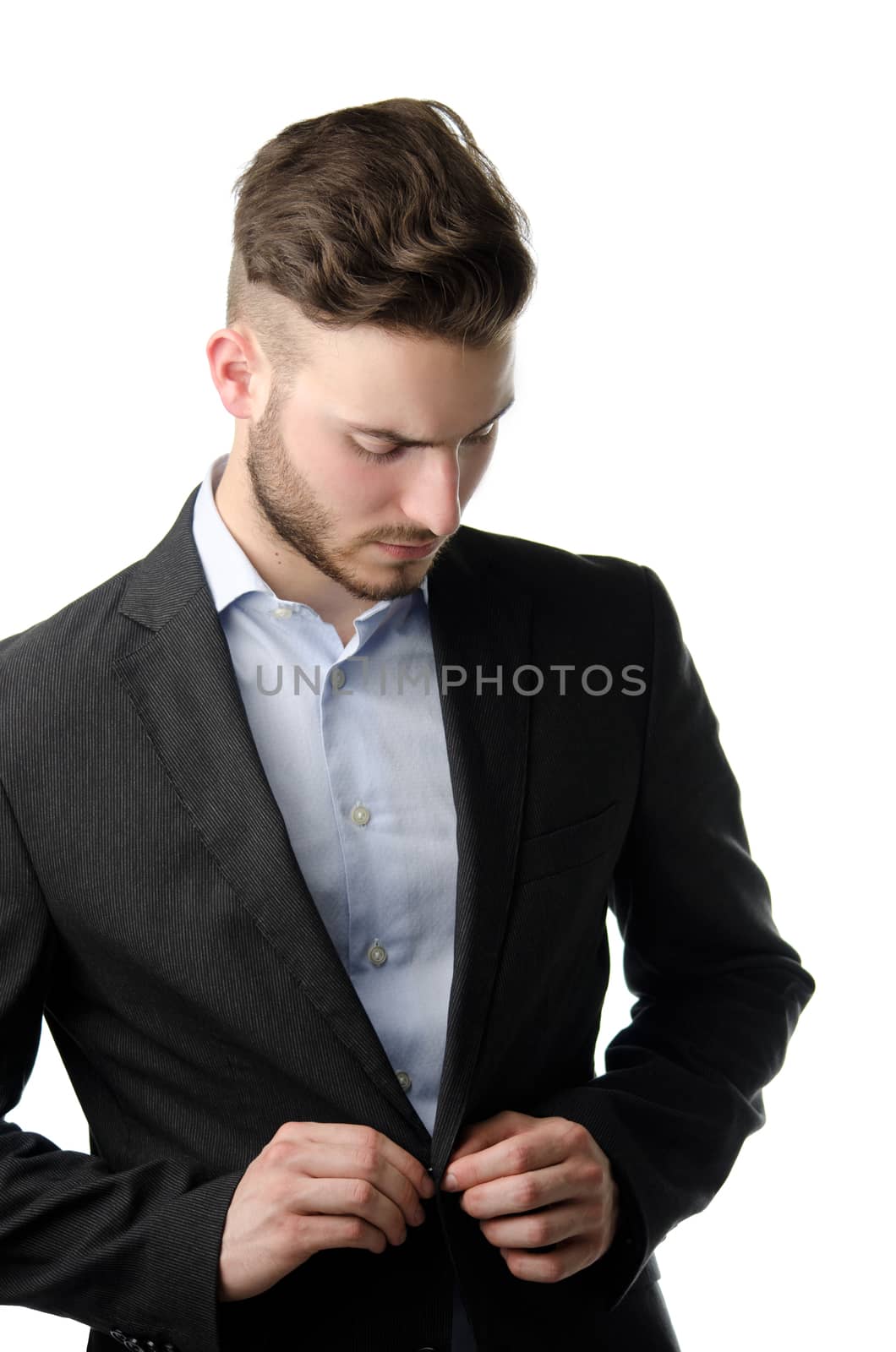 Attractive young man in suit buttoning up elegant jacket, isolated on white