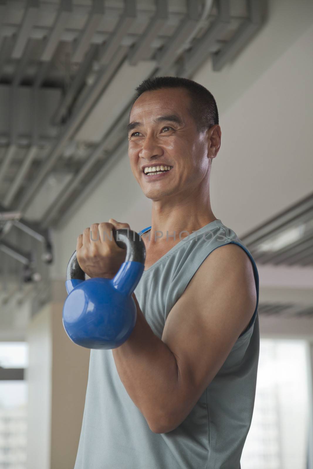 Mature man lifting weights in the gym