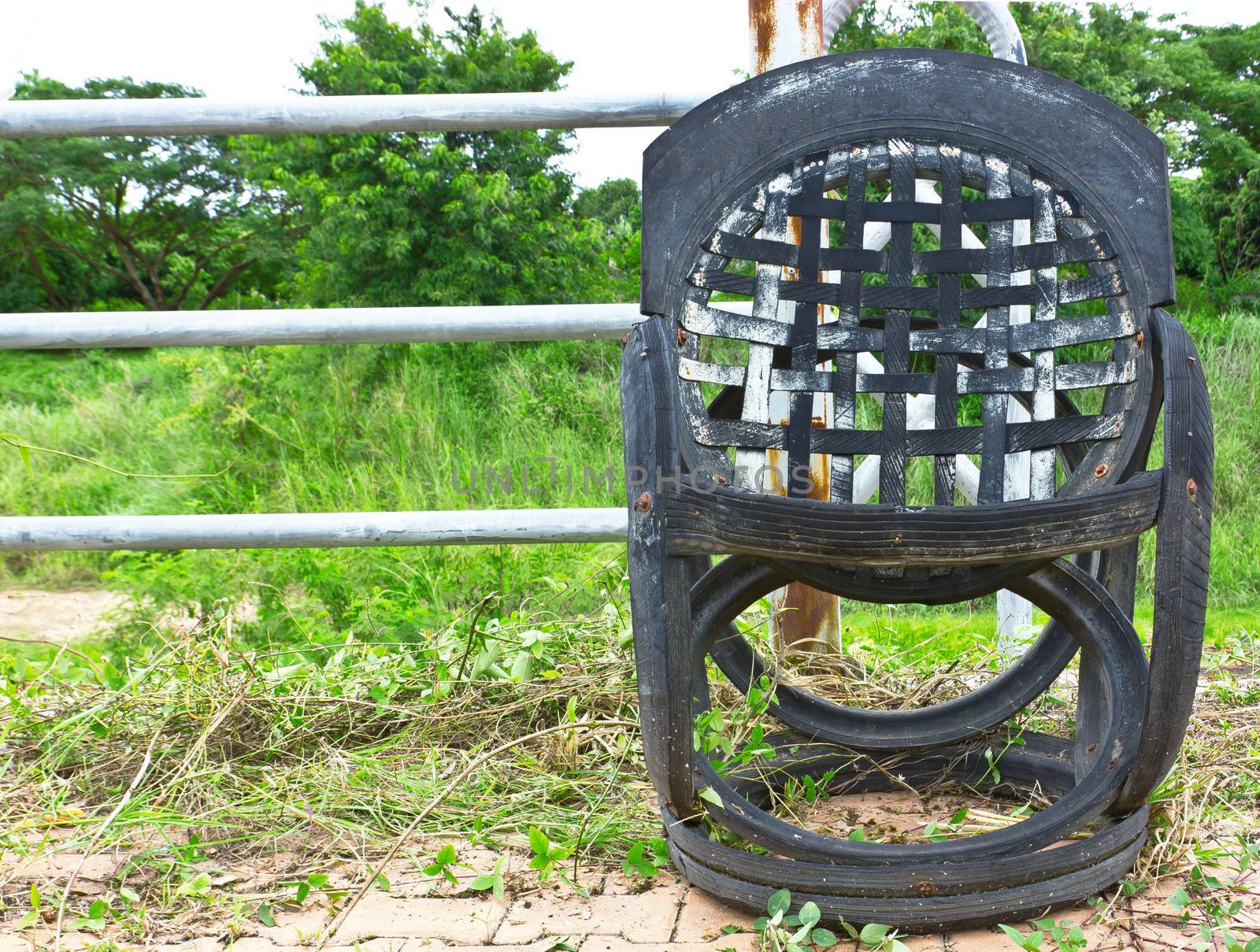 old chair beside the iron fence by sutipp11
