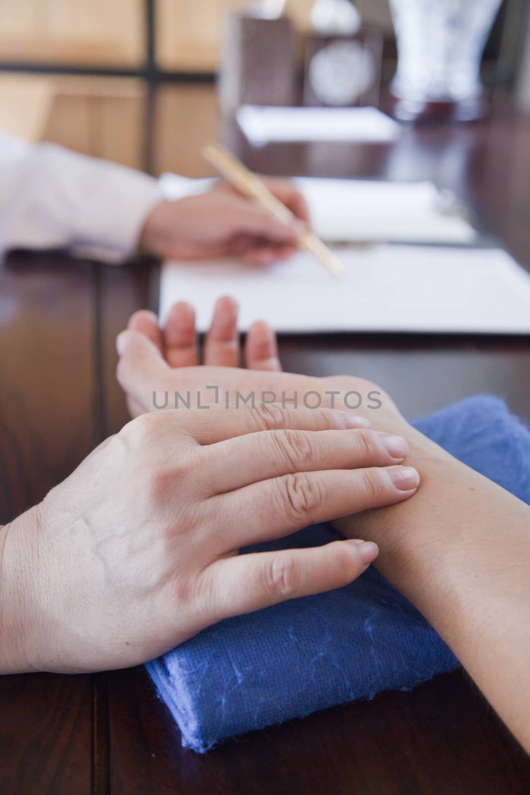 Close Up of Patient's Hand While Doctor Takes Pulse by XiXinXing