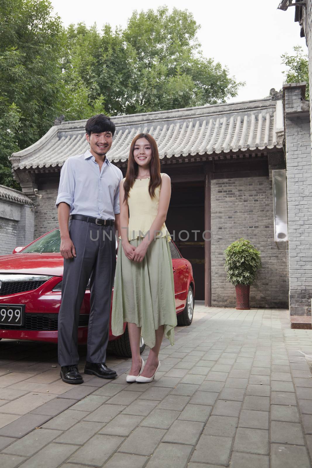 Young Couple in Front of Their Car