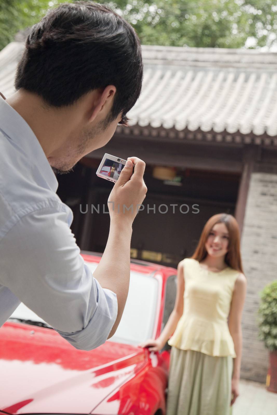 Young Man Taking a Picture of His Girlfriend and Car by XiXinXing