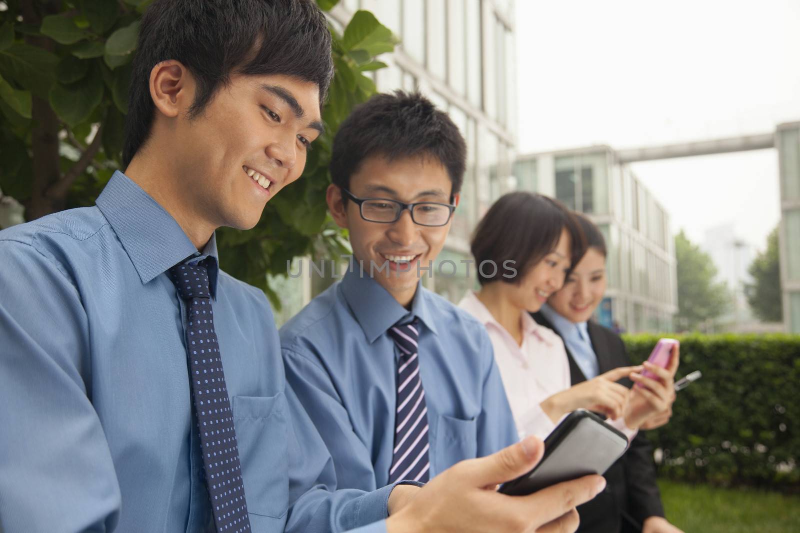 Young business people checking their cell phones