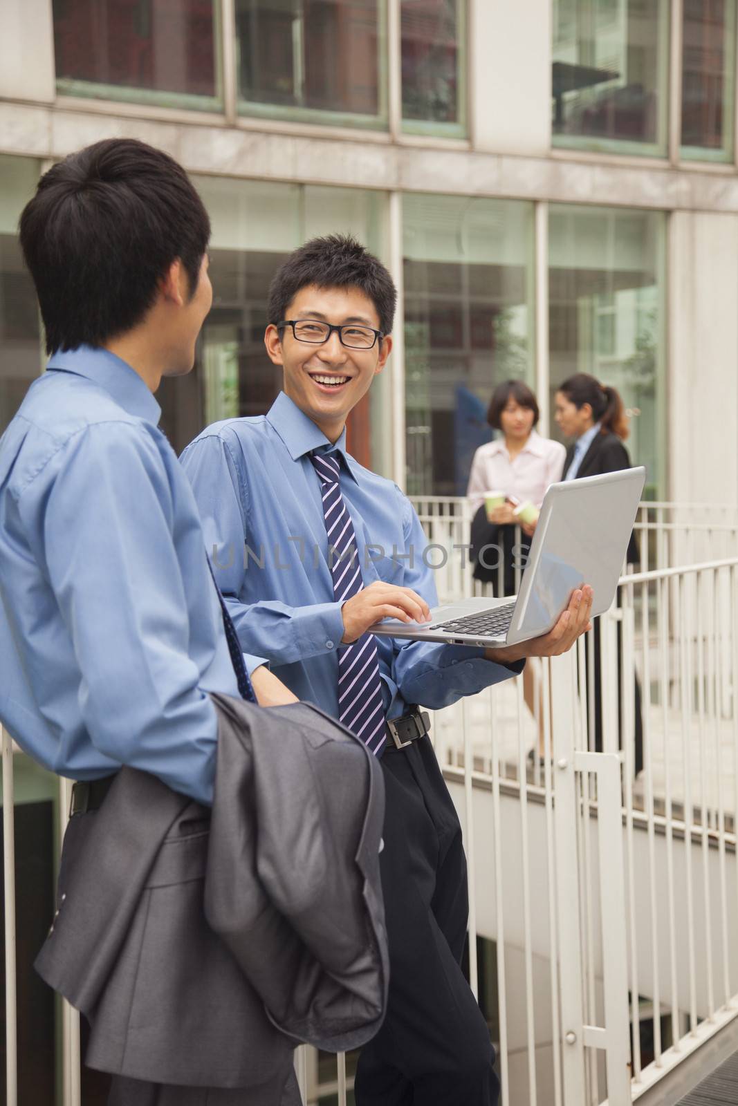 Businessmen working outside with laptop