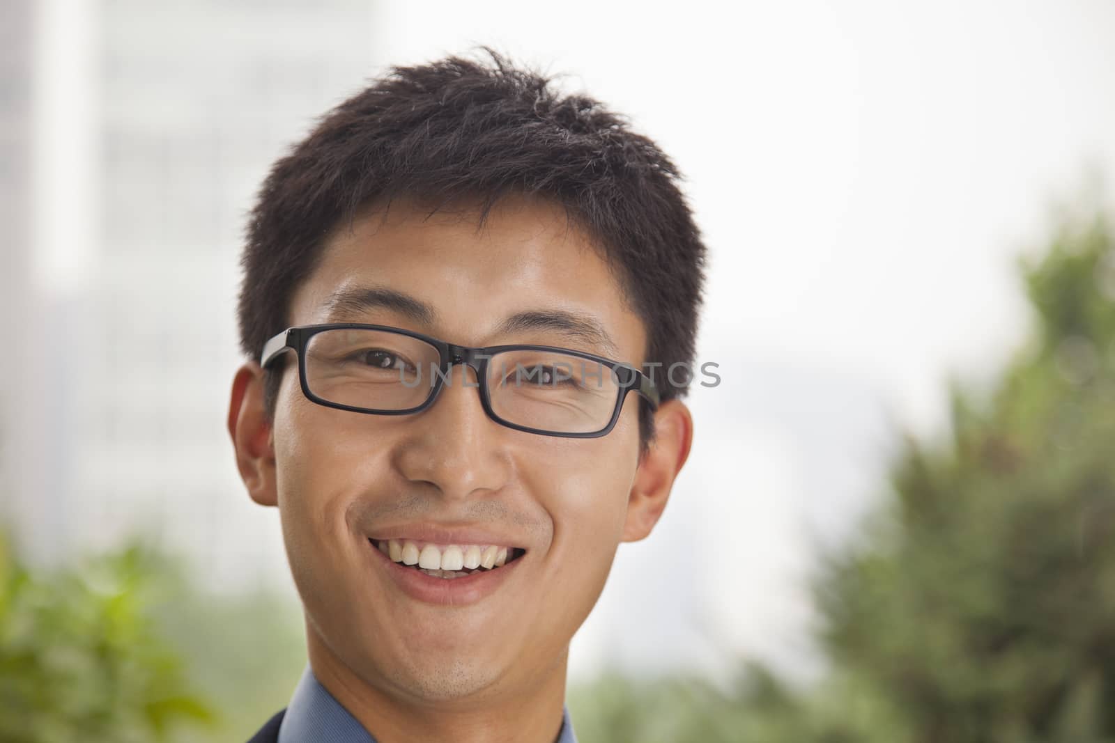 Young businessman smiling in the park, portrait