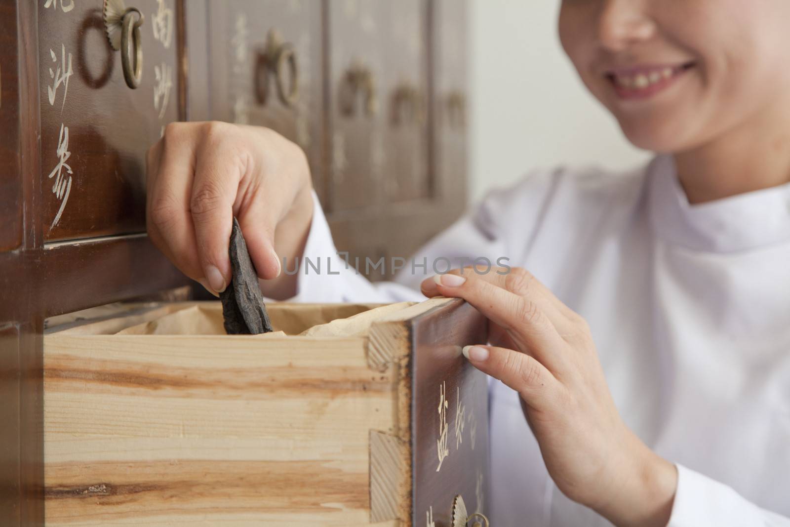 Doctor Taking Herb Used for Traditional Chinese Medicine Out of a Drawer