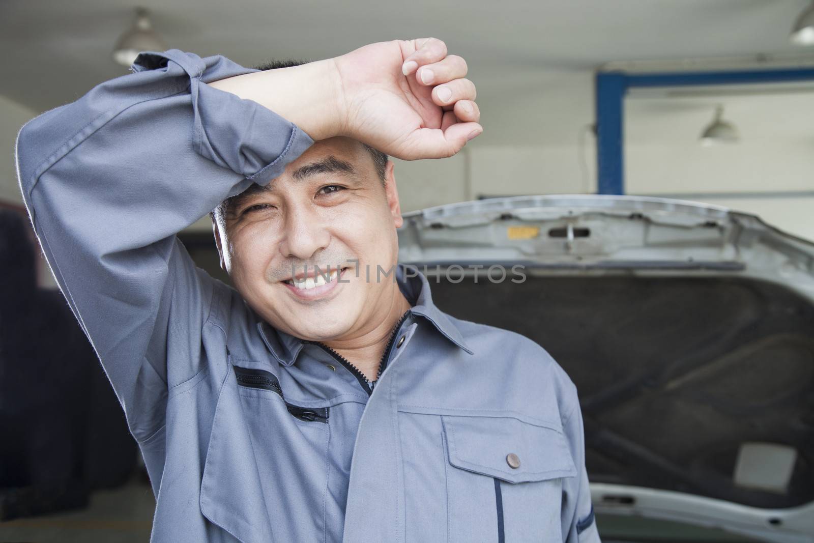 Auto Mechanic Wiping the Sweat Off His Brow