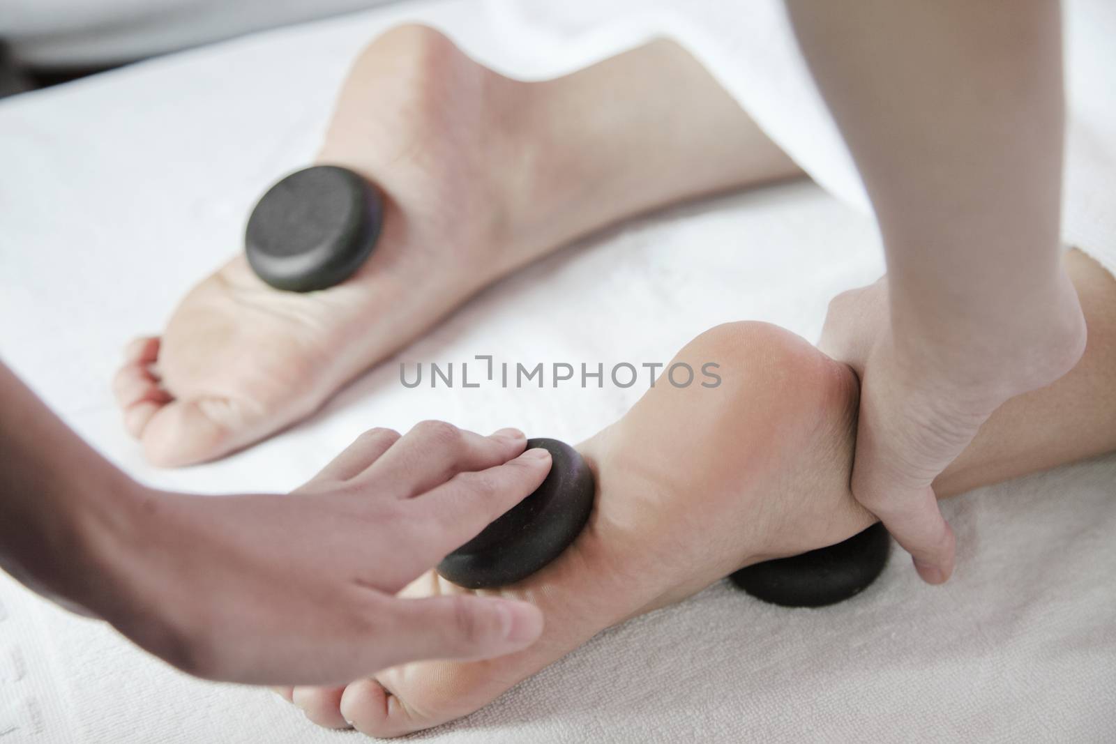 Woman Receiving Hot Stone Foot Massage by XiXinXing