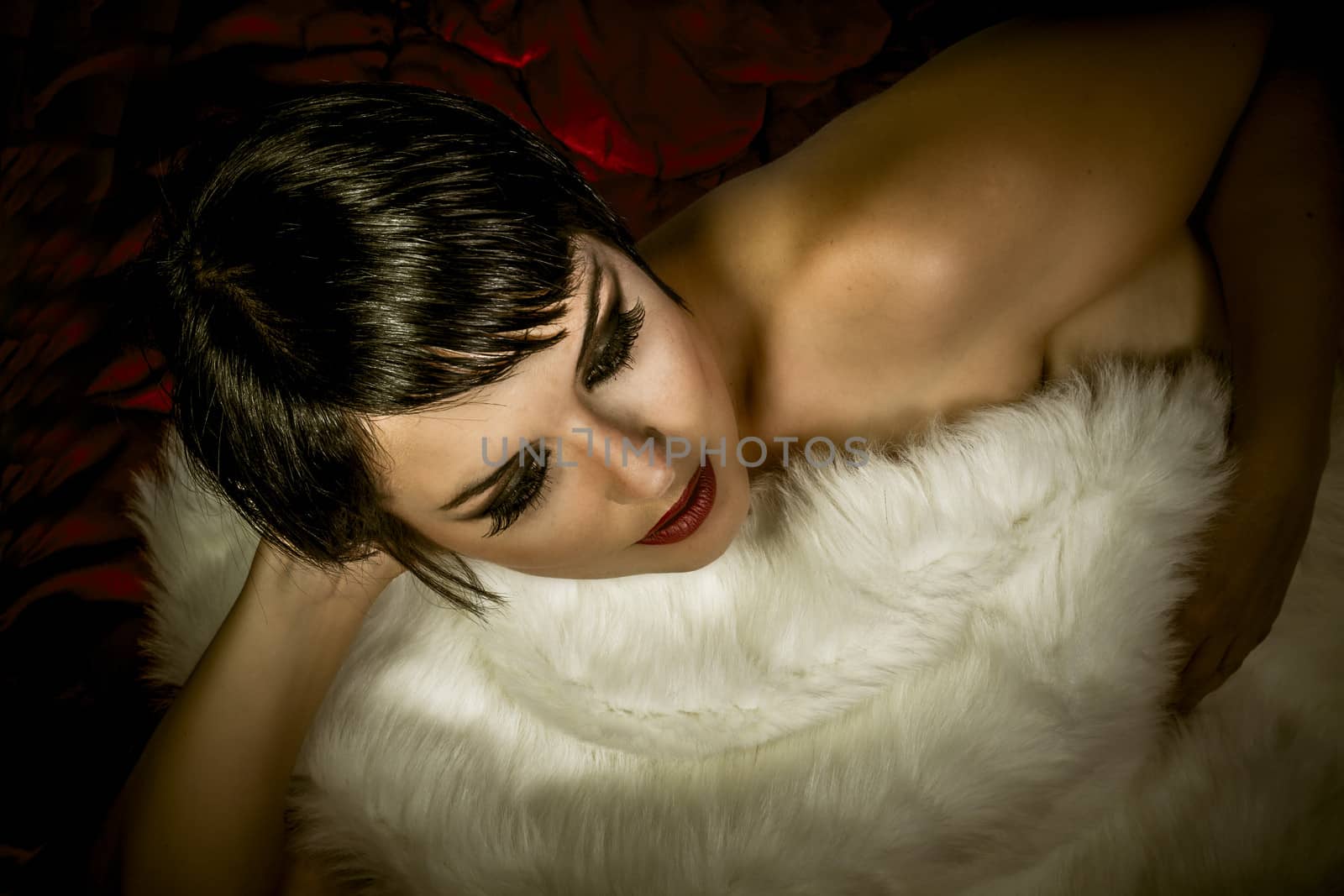 Sensual brunette woman lying naked on red silk, detail