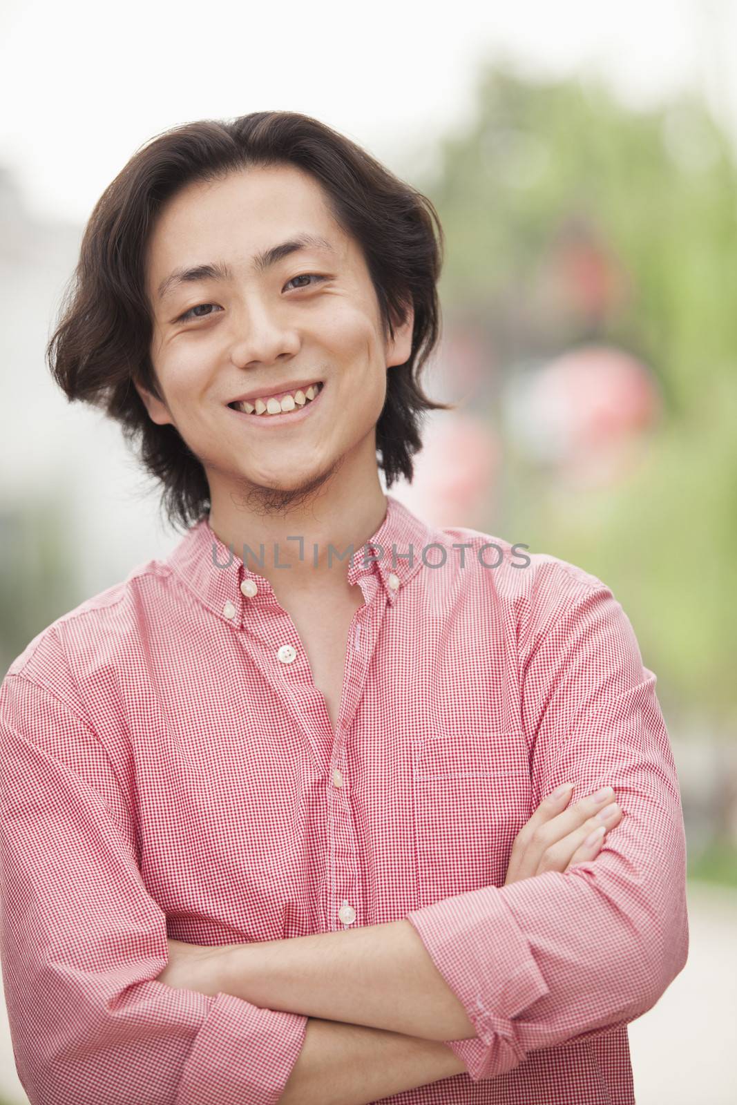 Smiling Young Man with Long Hair in Nanluoguxiang, Beijing, China