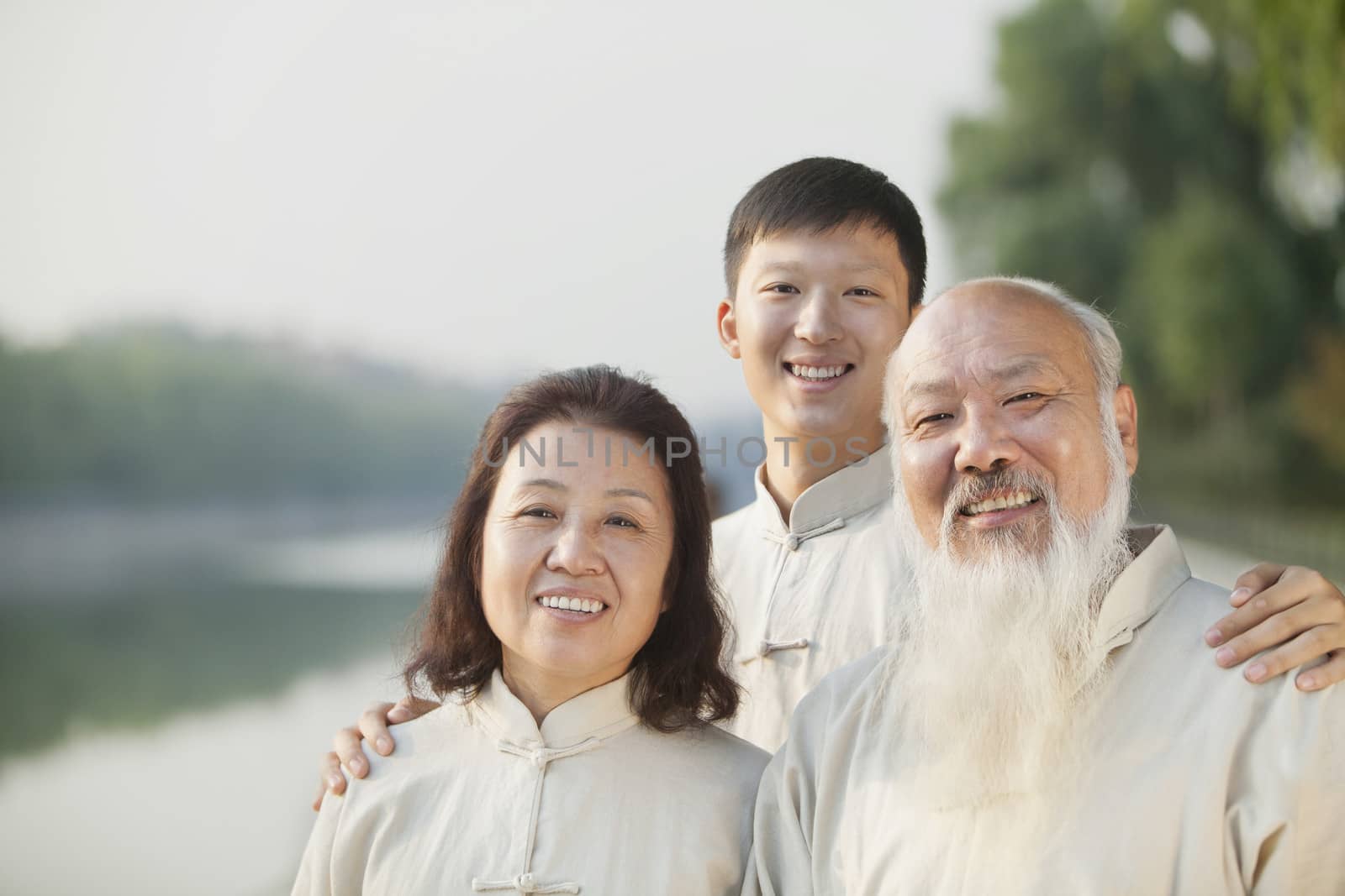 Three Chinese People With Tai Ji Clothes Smiling At Camera