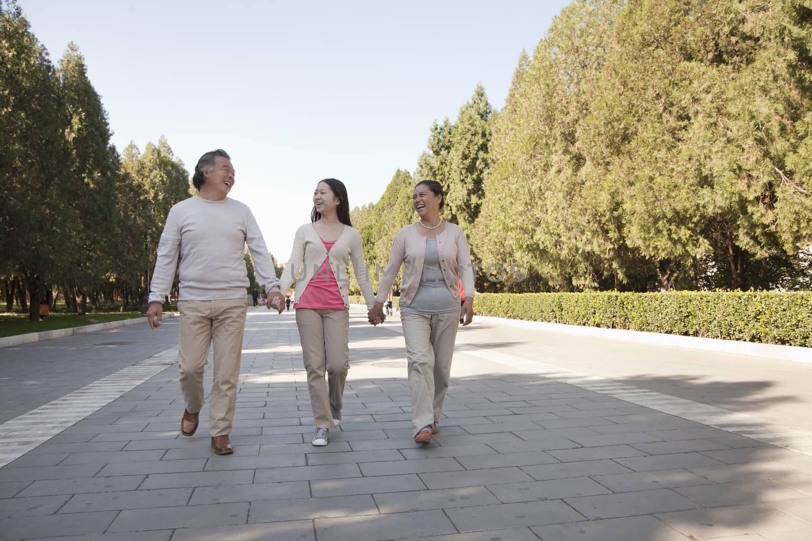 Granddaughter with grandparents walking in the park  by XiXinXing
