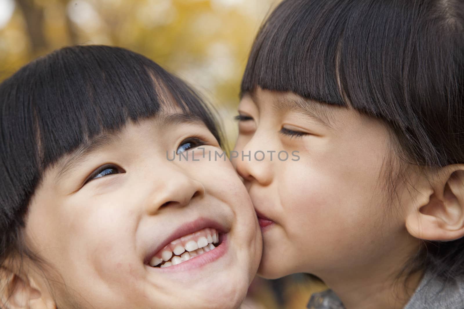 A girl kissing her older sister