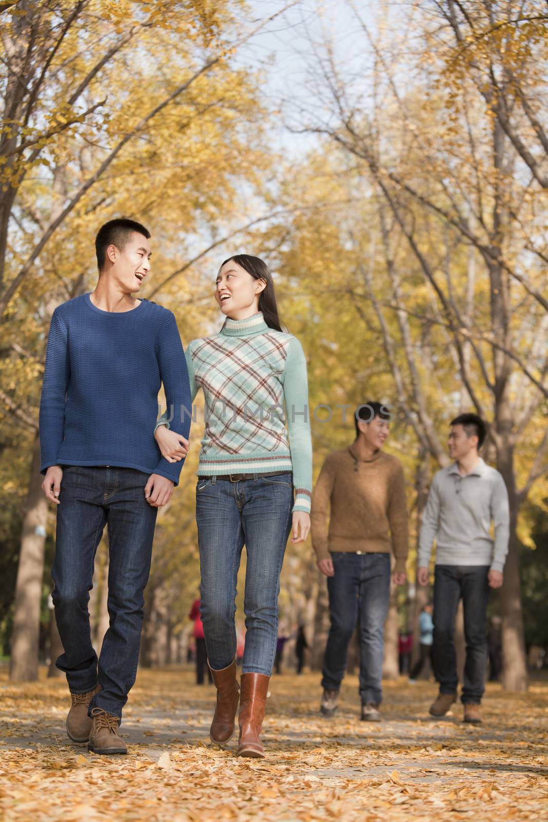 Friends walking together in park by XiXinXing