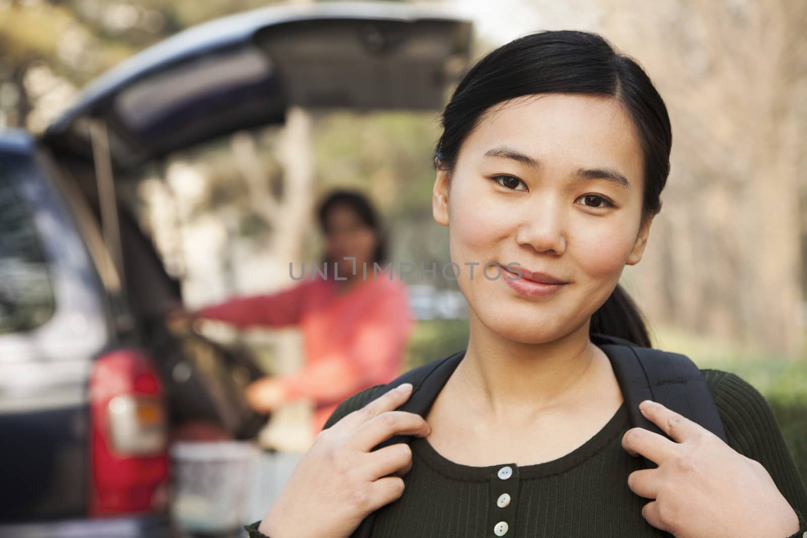 Portrait of girl in front of car on college campus