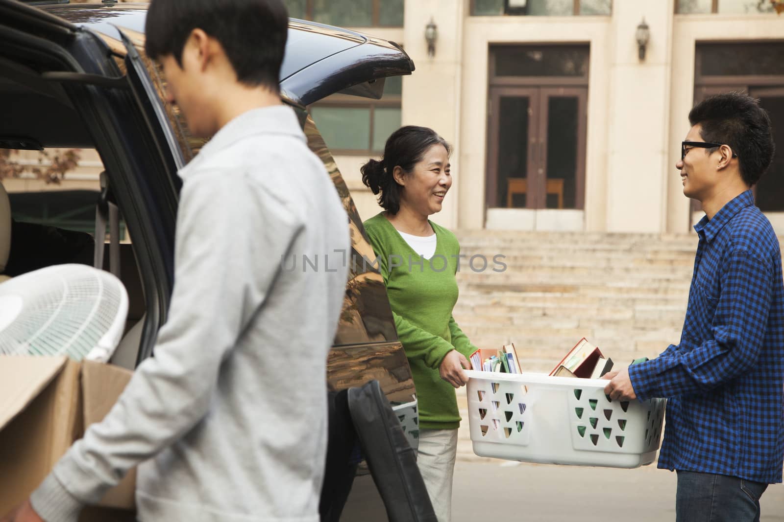 Family moving their son into dormitory on college campus by XiXinXing
