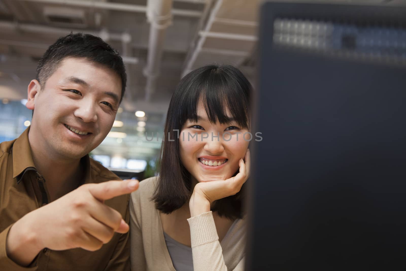 Two Business People Looking at Computer in the Office