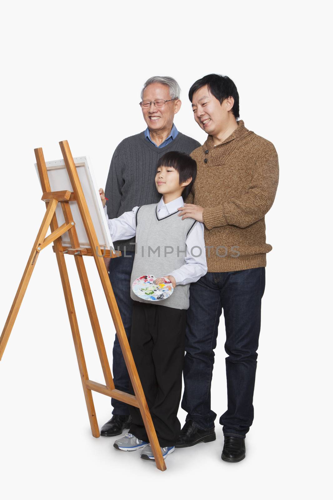Boy painting with father and grandfather