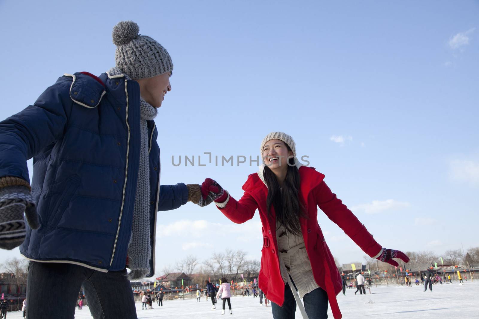 Young couple skating at ice rink