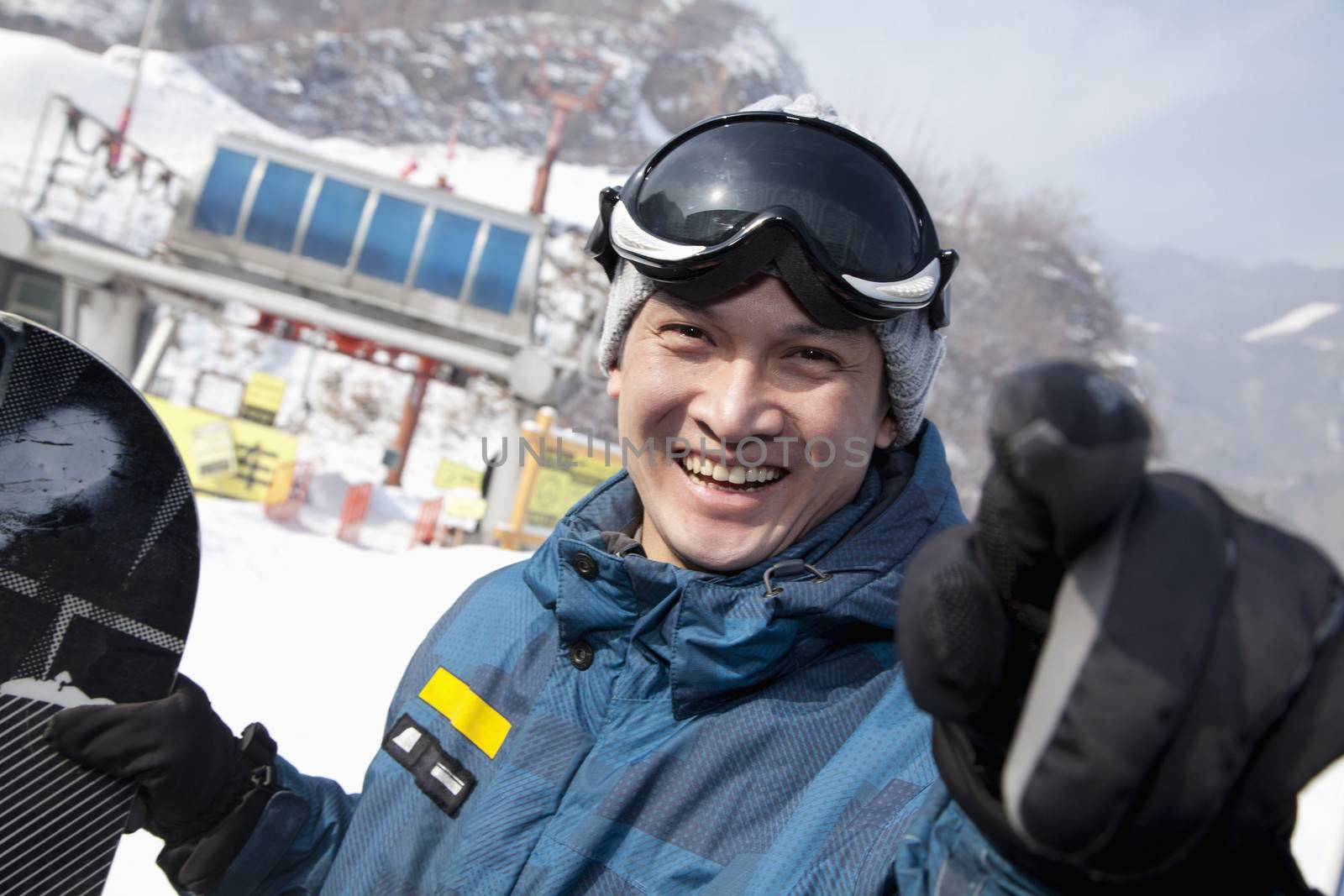 Smiling Snowboarder in Ski Resort