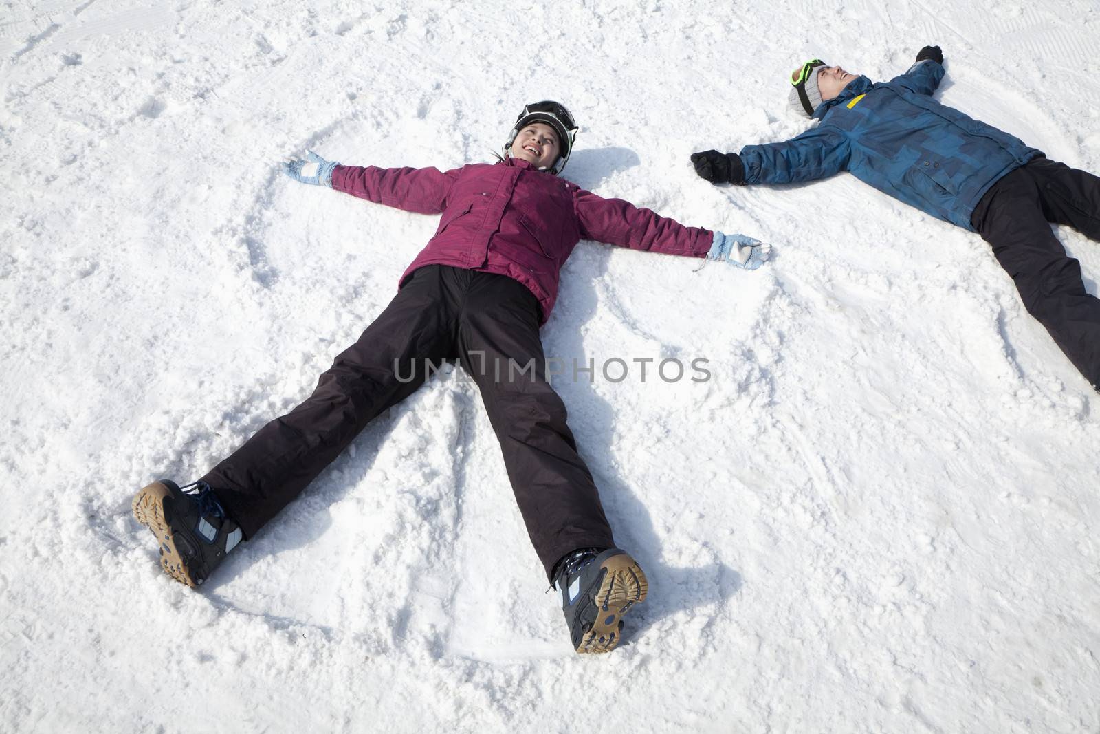 Man and Woman Lying on the Snow Making Snow Angel by XiXinXing