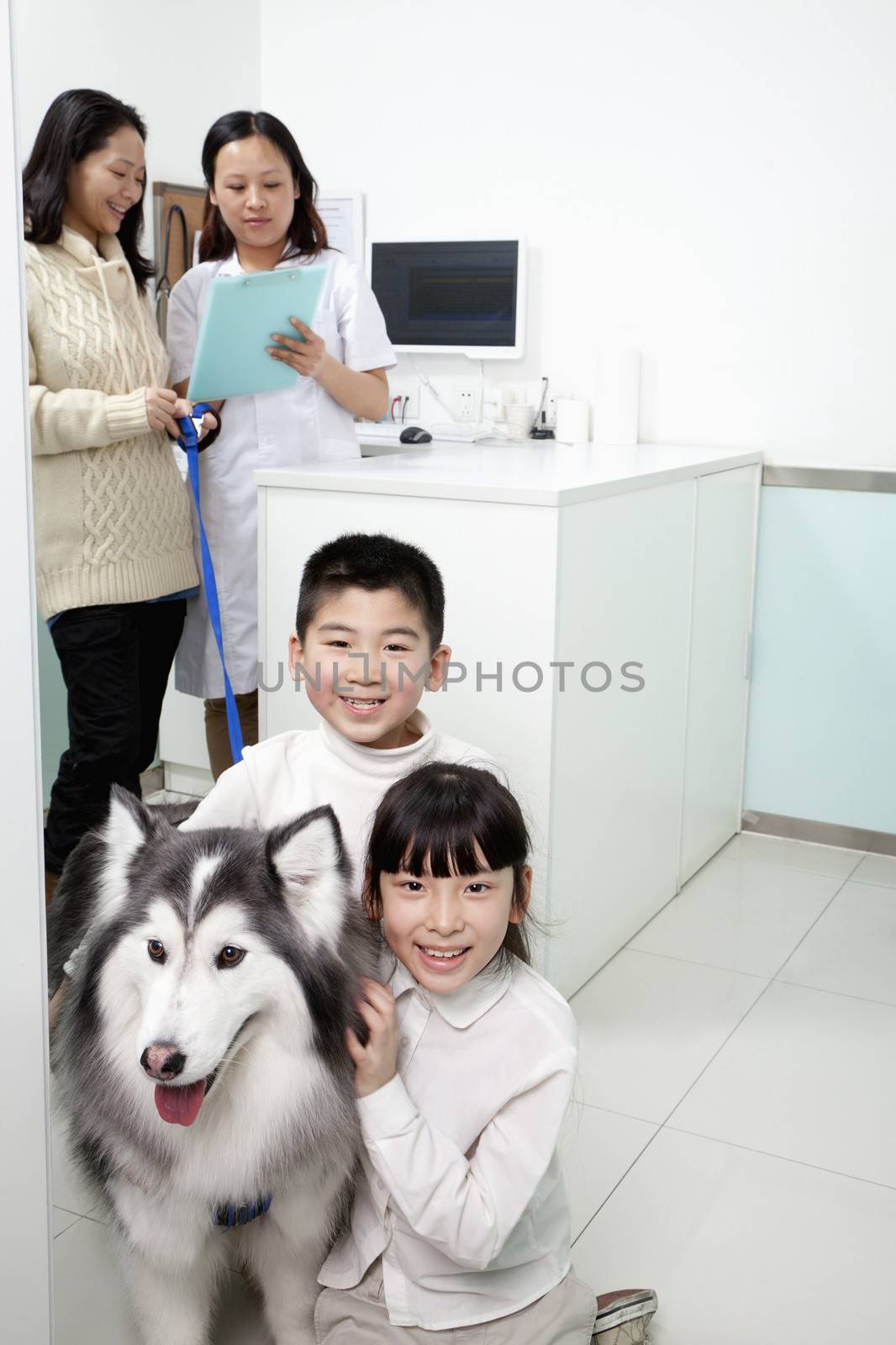 Family with pet dog in veterinarian's office