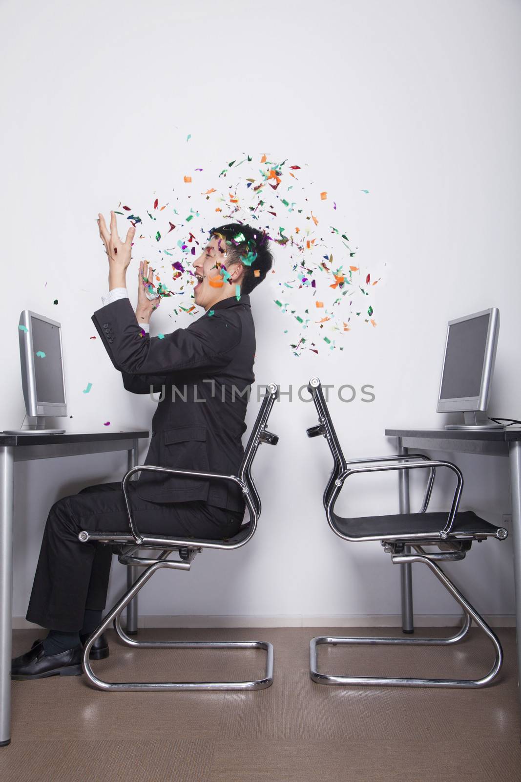 Young Businessman throwing confetti in the office