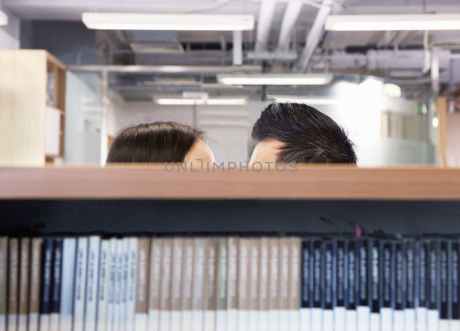 Work romance between two business people hiding behind shelves by XiXinXing