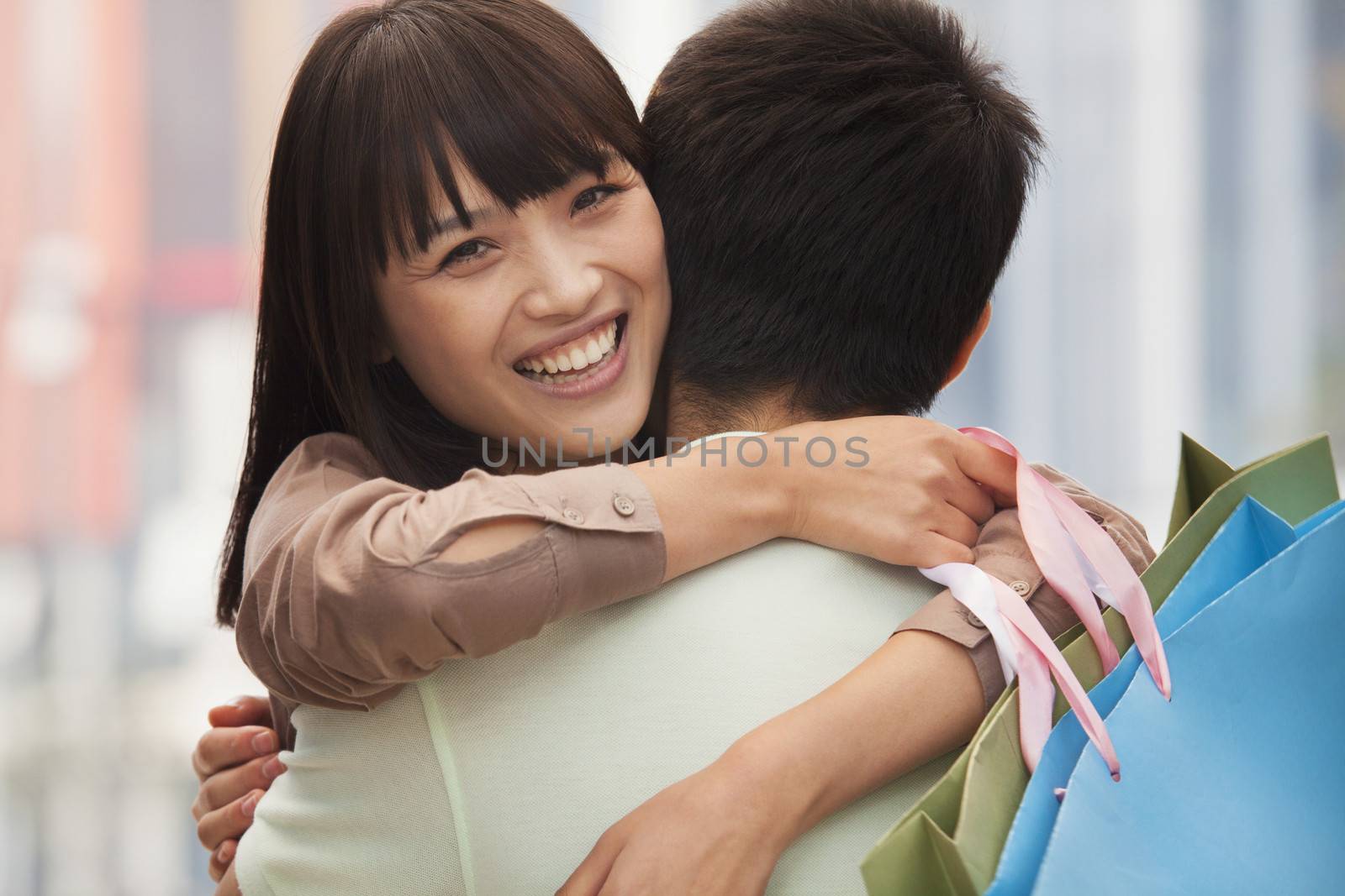 Young couple embracing with shopping bags, outdoors, Beijing