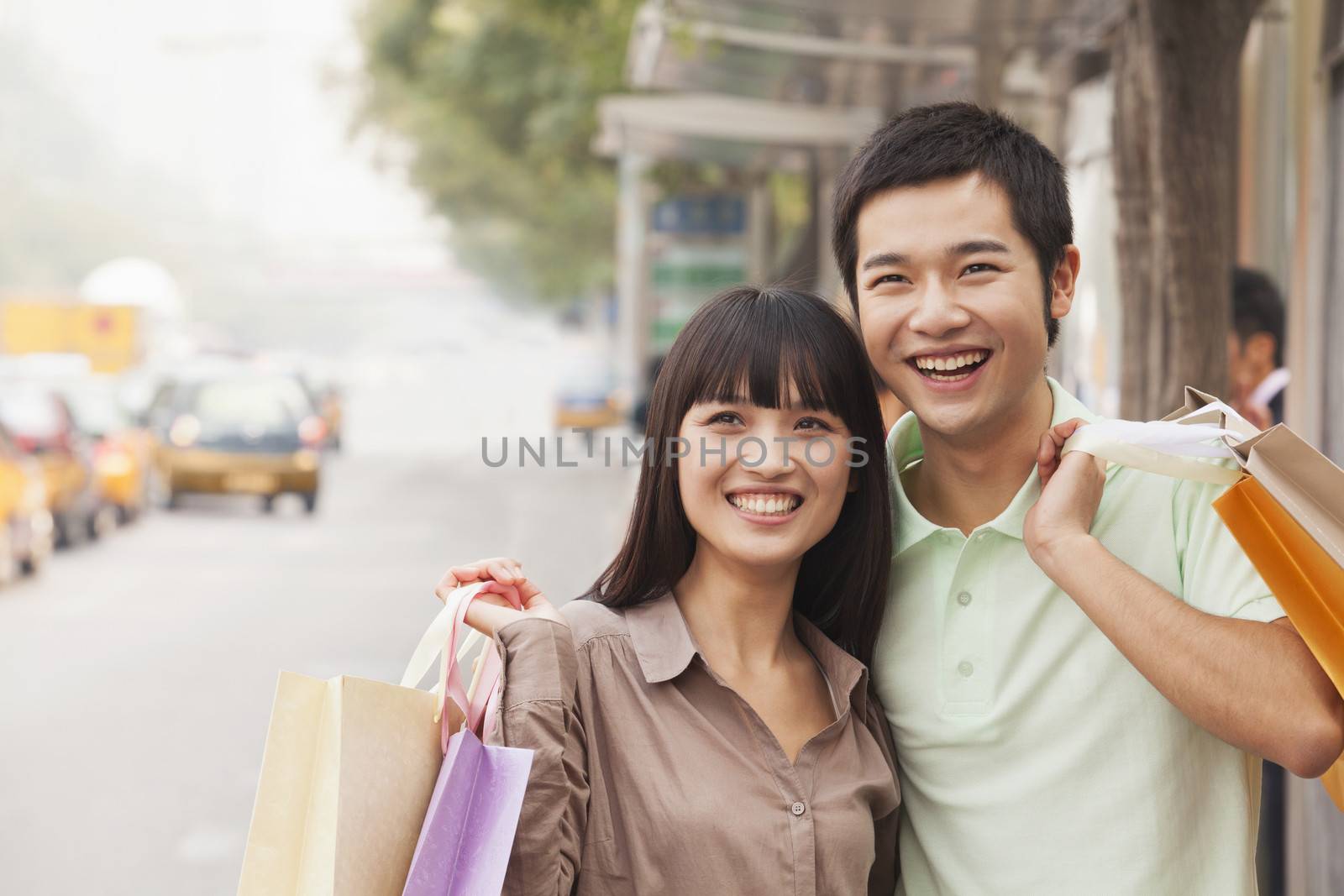 Portrait of smiling young couple at the bus stop, Beijing, China