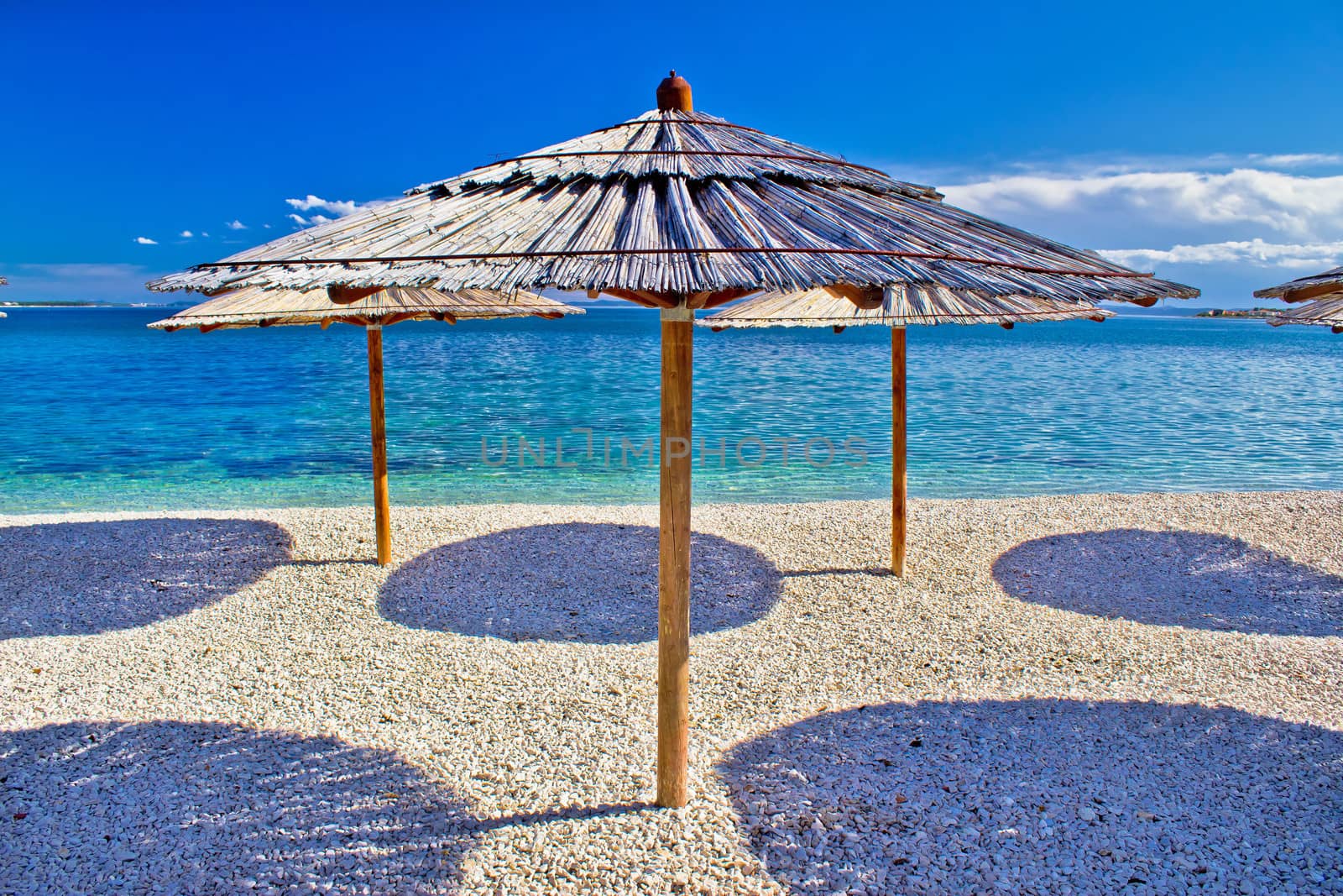 Pebble beach and turquoise sea umbrella, Zrce beach, Island of Pag, Croatia