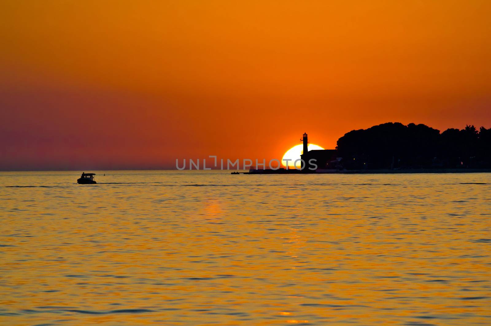 Lighthouse in Zadar and boat on the sea epic sunset, Dalmatia, Croatia