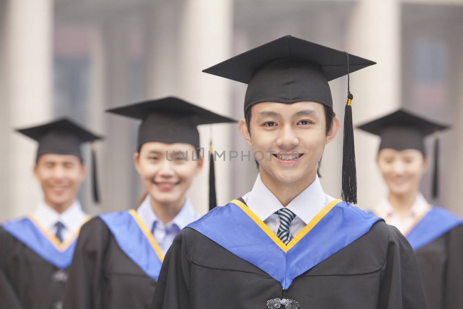  Four University Graduates Smiling, Looking at Camera by XiXinXing