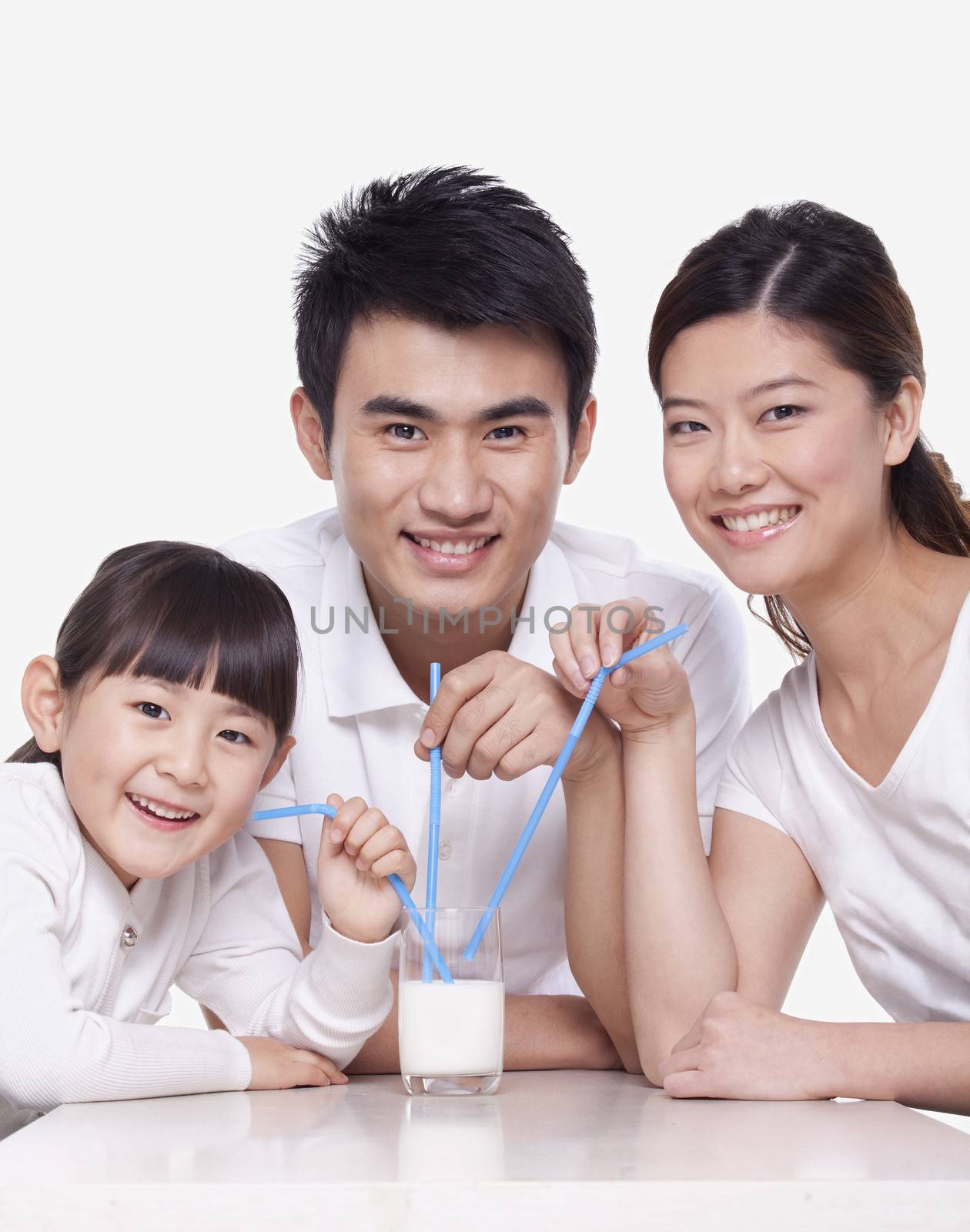 Family sharing a glass of milk, studio shot by XiXinXing