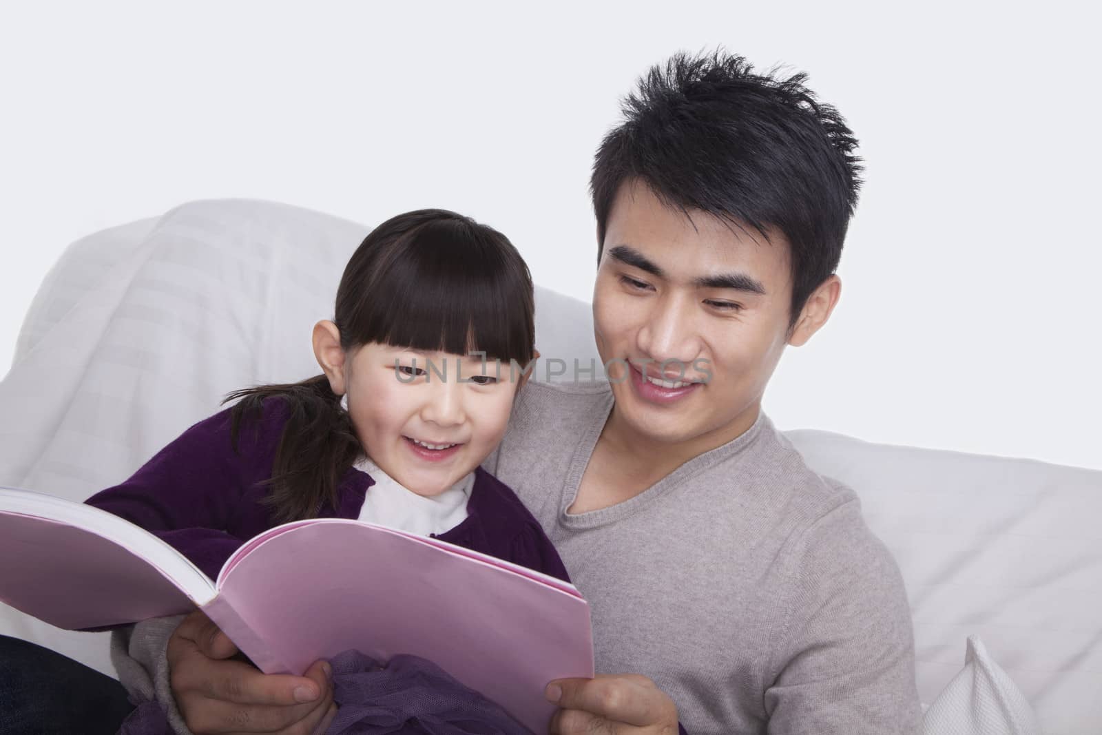 Father and daughter reading on the sofa