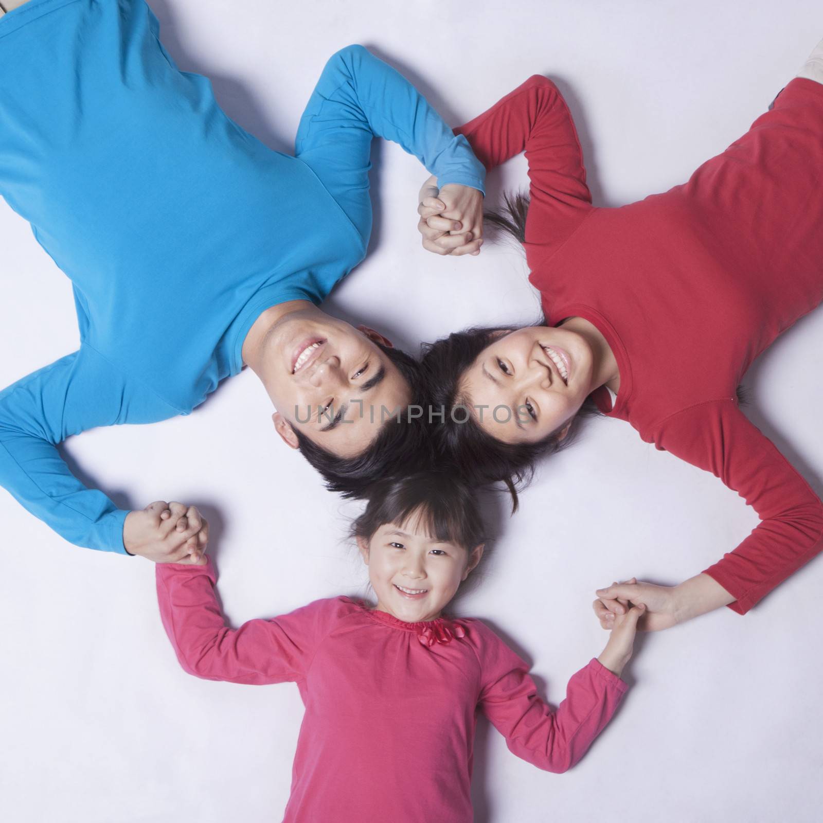 Family holding hands in a circle, shot directly above by XiXinXing