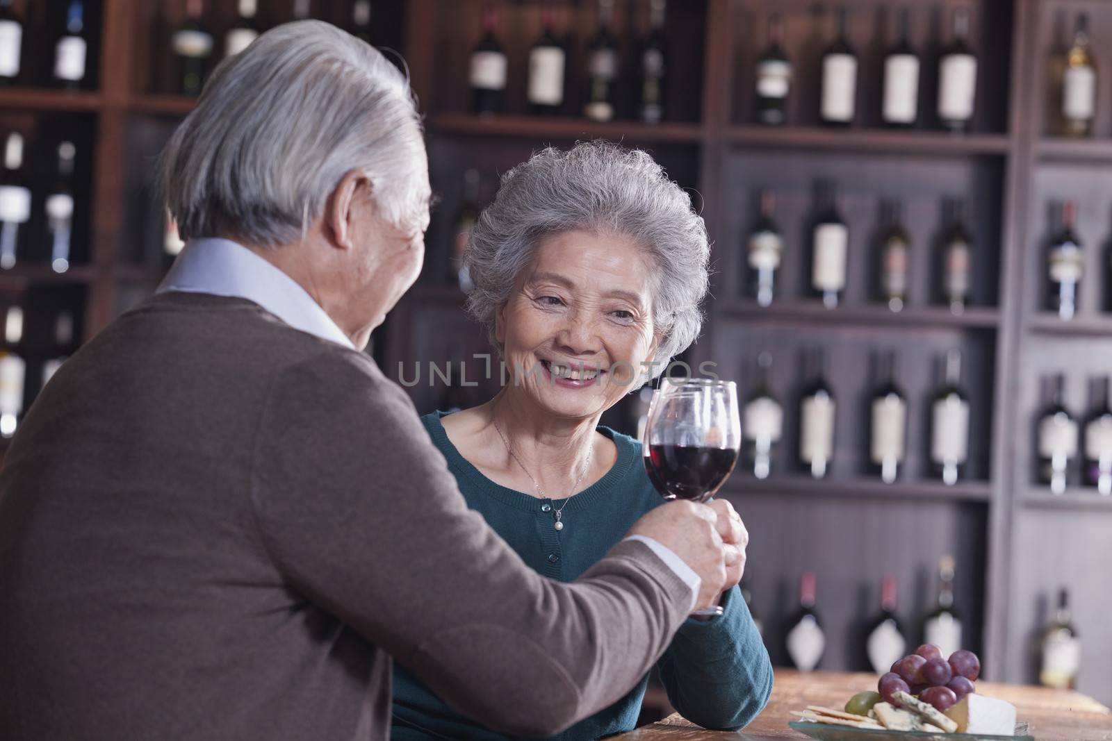 Senior Couple Toasting and Enjoying Themselves Drinking Wine, Focus on Female