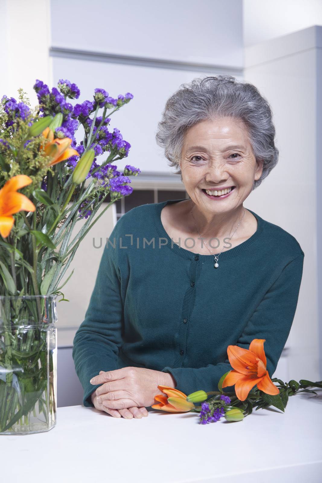 Senior Woman Beside Bouquet of Flowers in the Kitchen, Portrait