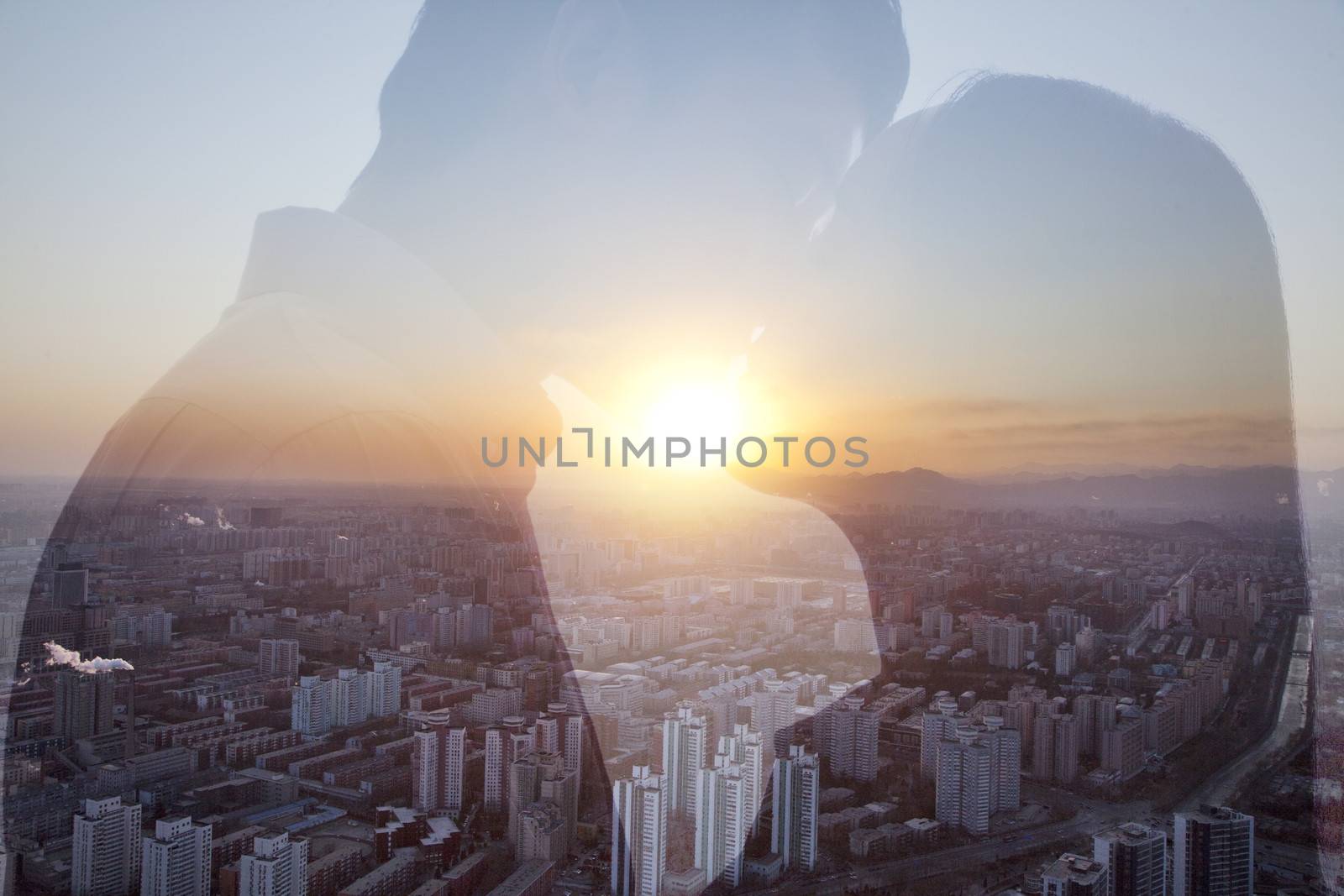 Double exposure of couple kissing over cityscape