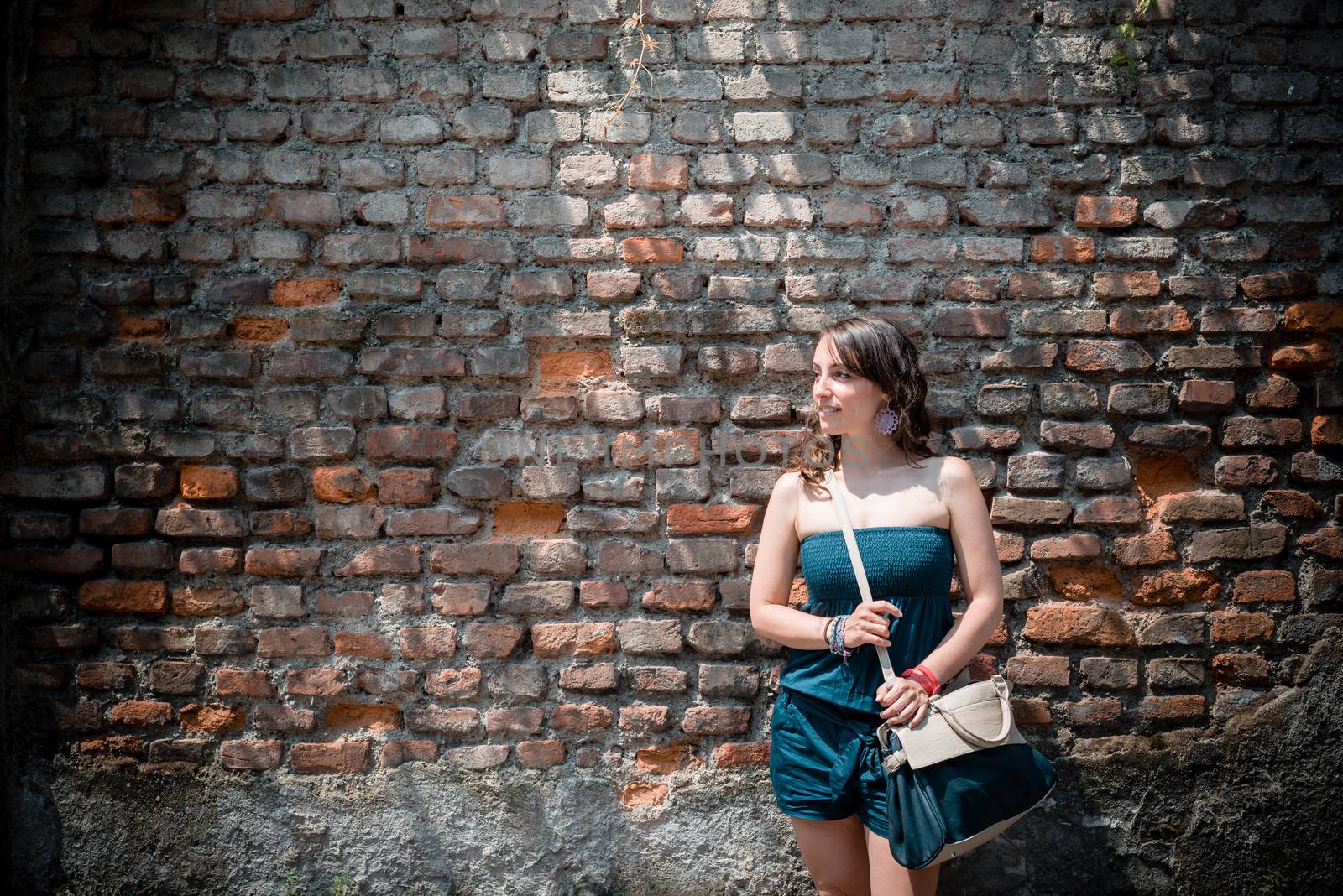 beautiful woman in the city on a brick wall