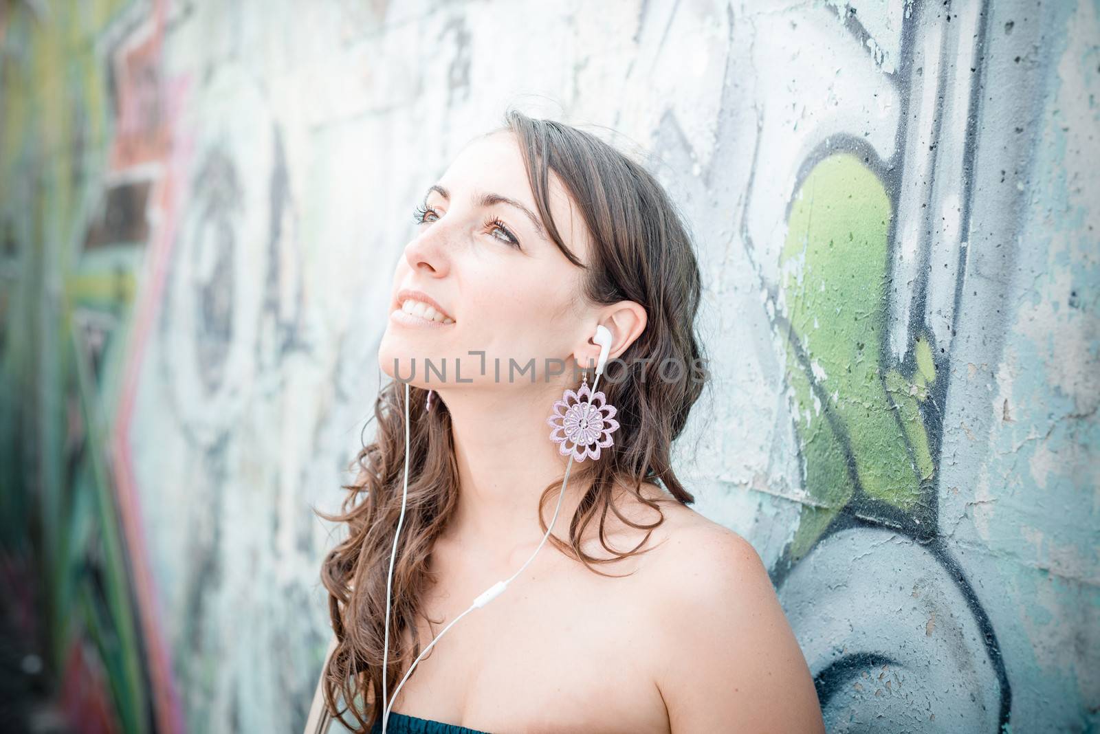 beautiful woman listening to music with phone player in the city